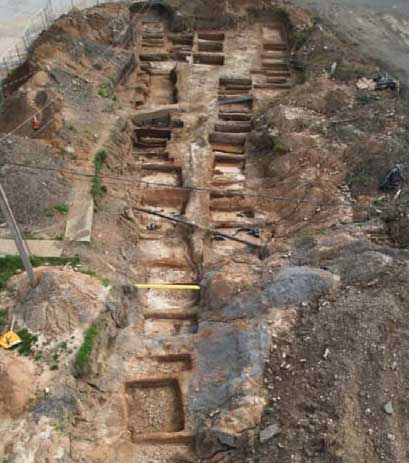 Aerial photograph of multiple excavated grave shafts.
