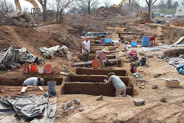 Archaeologists work to expose graves.
