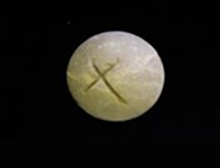 A marble incised with an “X” mark.