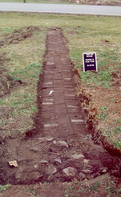 A brick sidewalk extending from the house to Paris Pike.