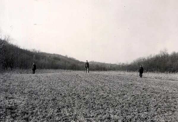 Workers stand along edges and top of extant mound