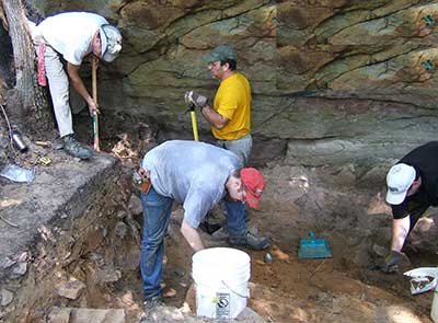 Archaeologists excavate the Twin Knobs Rockshelter. Note its small size.