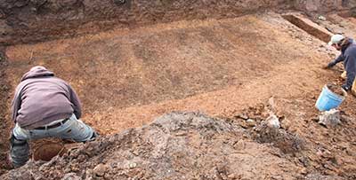 Archaeologists expose a single rectangular grave shaft that contained multiple coffins.